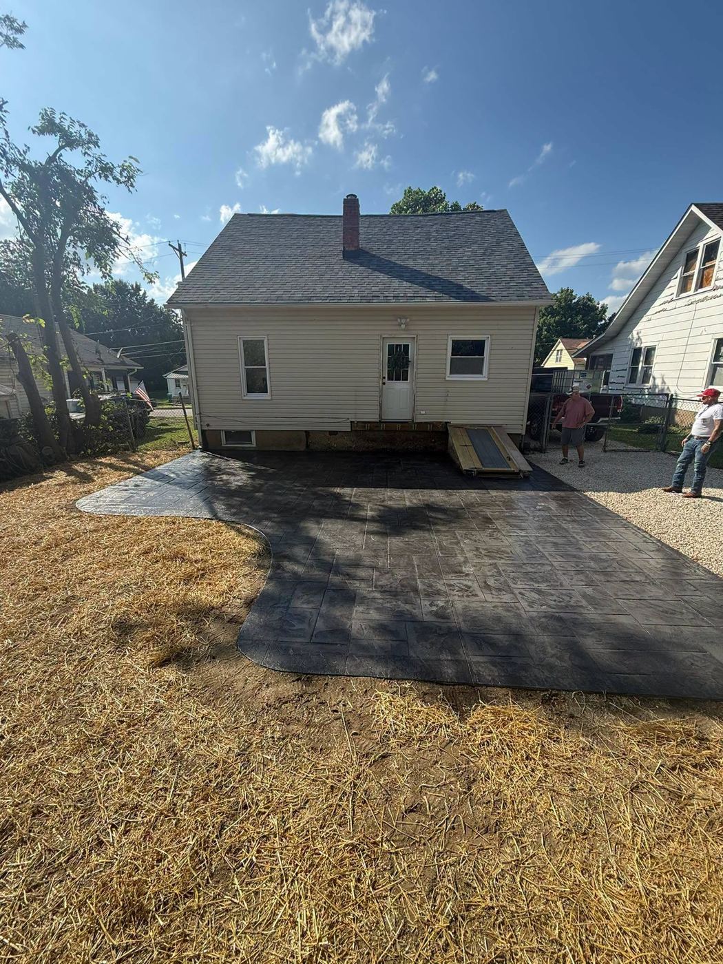 Charcoal stamped concrete patio behind a house