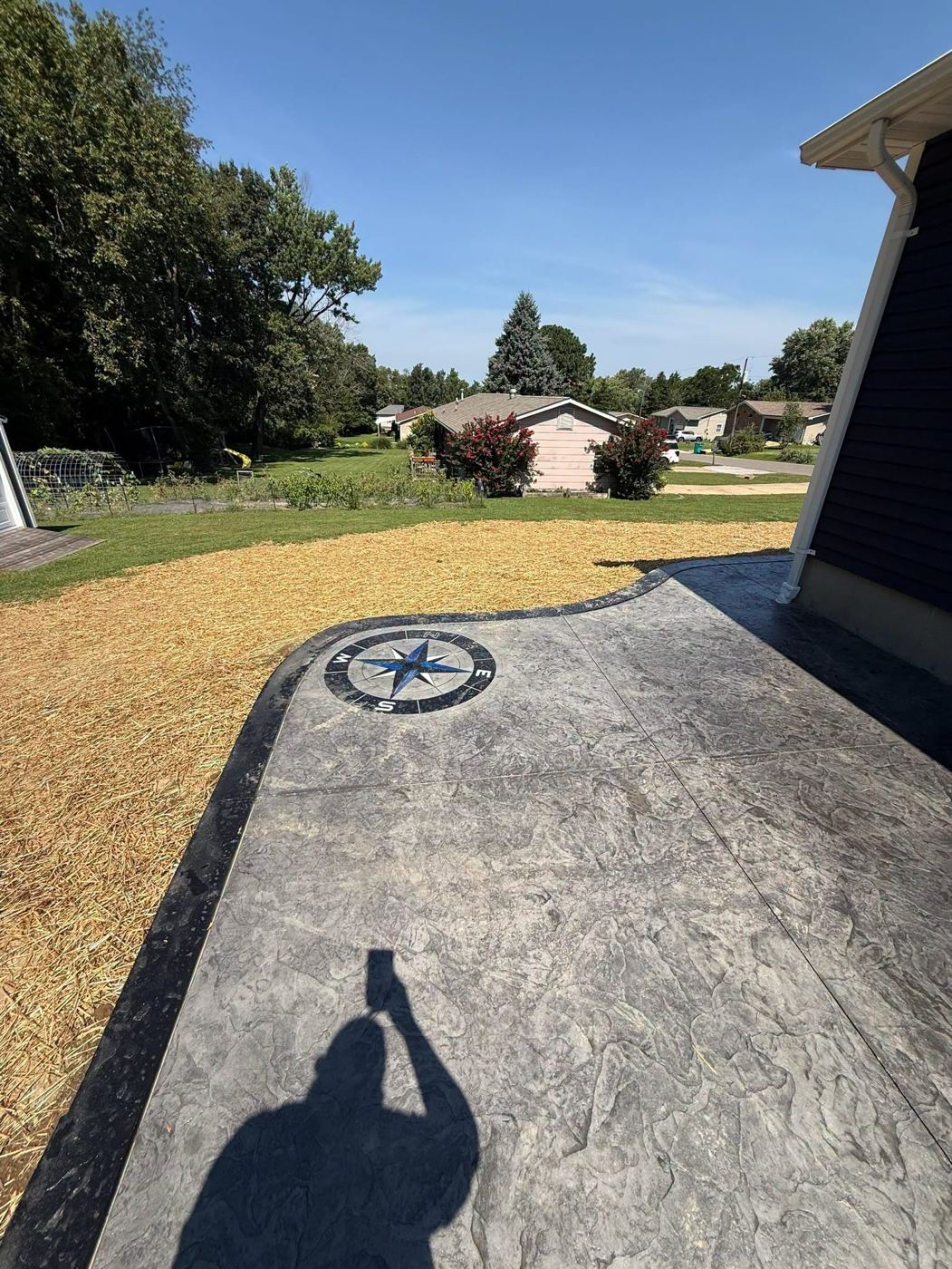 Gray stamped concrete patio with a blue compass rose inlay