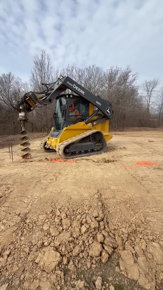 John Deere track loader working on a graded dirt site